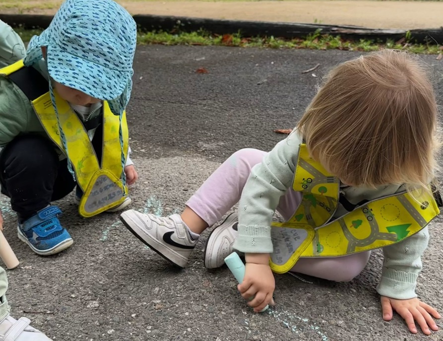 Les enfants dessinent à la craie.