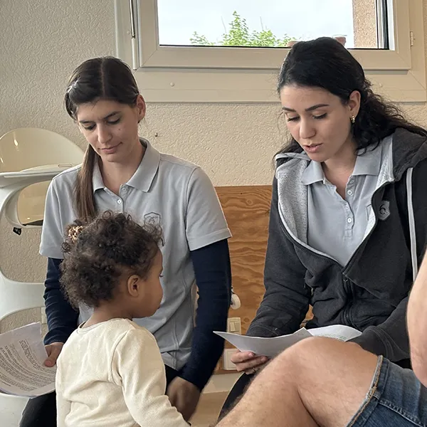 Atelier de langage des signes à la crèche 6 Sens à Saint-Sulpice : une éducatrice montre un geste à un parent curieux